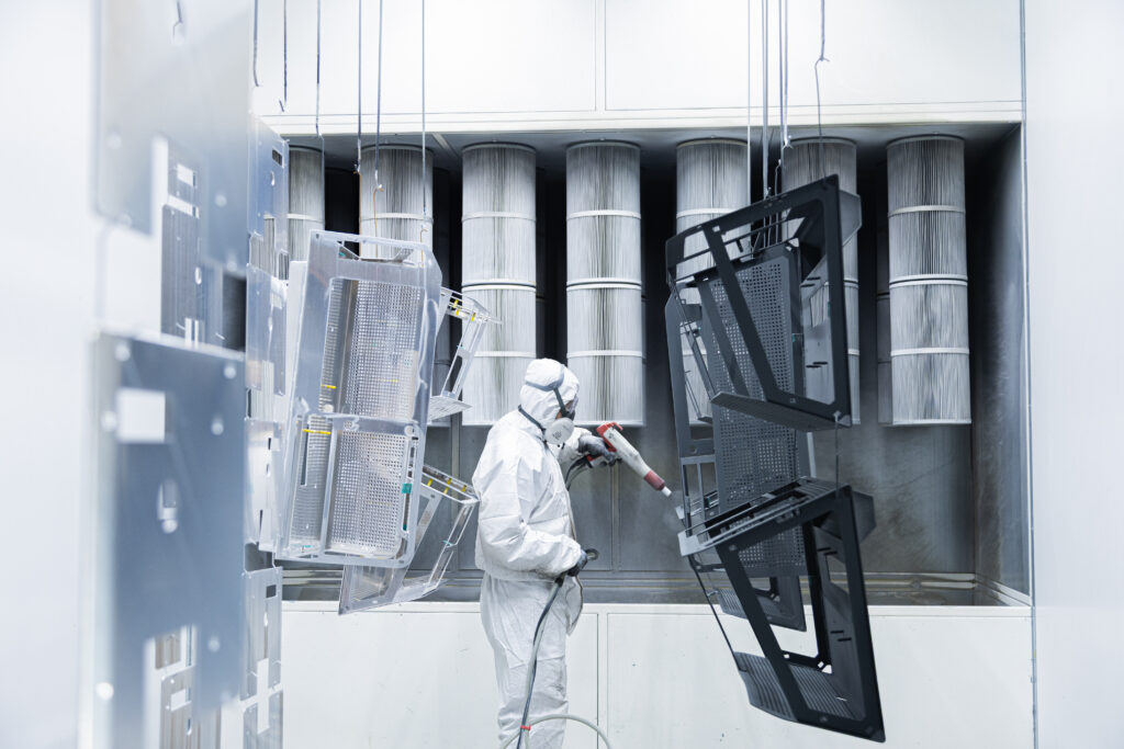 Pintor pintando piezas con pintura polvo