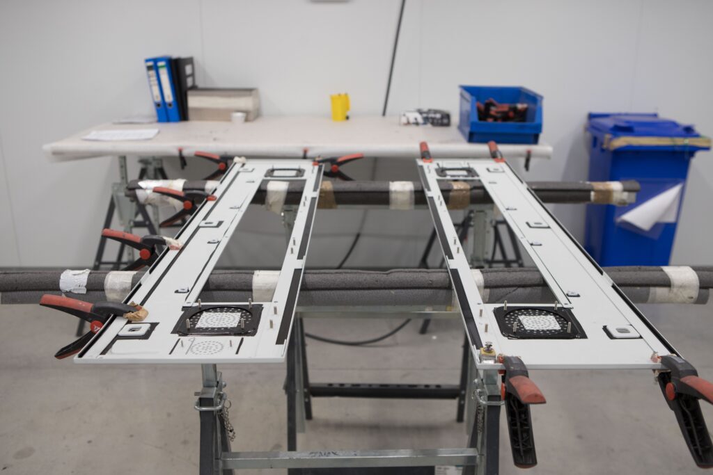 Pieza en cabina industrial de adhesivado