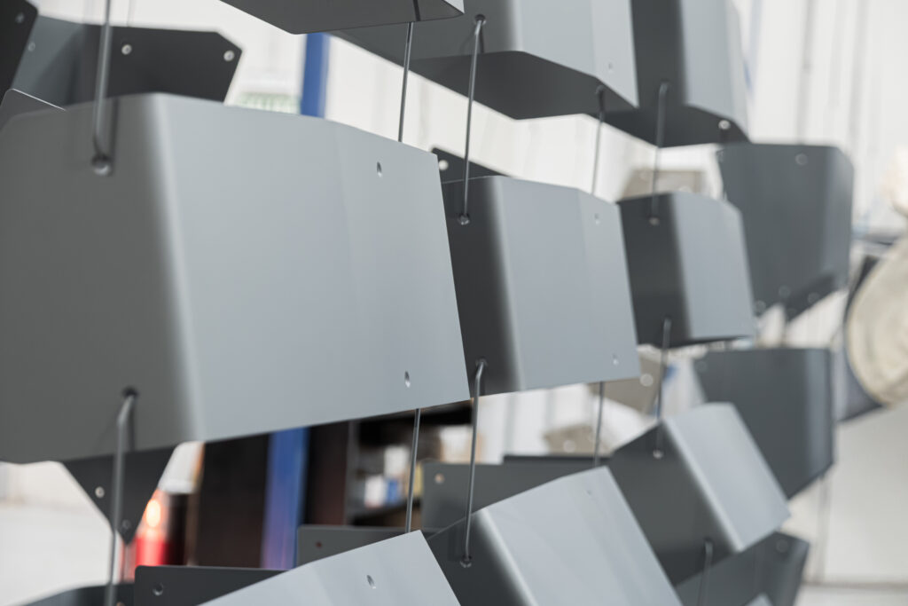 Piezas metálicas secándose al aire tras pintura con polvo